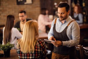 Um garçom freelancer prestando serviço em um evento elegante, demonstrando profissionalismo e atenção aos detalhes, características essenciais para o sucesso na área - freepik